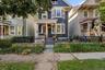 Two-story dark blue siding exterior with bay windows