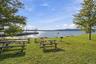 Waterfront property featuring a substantial dock, expansive grassy areas, and mature trees