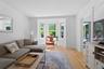 Hardwood flooring, bay window, crown molding, white trim, and a doorway with French doors