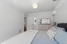 White walls with crown molding, ceiling-mounted light fixture, and white trim
