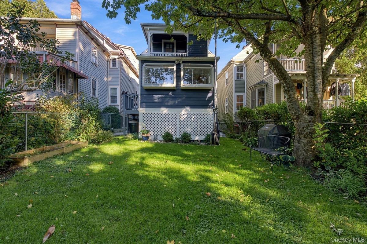 Expansive green lawn with mature trees and perimeter fencing