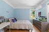 Hardwood flooring, window with natural light, crown molding, modern wall-mounted air conditioning unit, and a built-in dresser