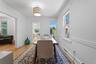 Hardwood flooring, white painted walls, decorative chair rail, recessed windows with white trim, and a contemporary ceiling fixture