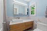 Floating wood-finish vanity with a vessel sink, white countertop, and wall-mounted medicine cabinet