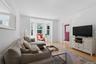 Hardwood flooring, bay window, white trim, recessed lighting, and a painted paneled door