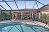 Screened lanai featuring a swimming pool, paved patio, and covered seating area