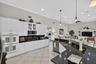 Kitchen featuring white cabinetry, dark stone countertops, stainless steel appliances, and tile flooring