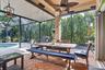 Screened outdoor patio featuring a ceiling fan, a dining area, and a swimming pool