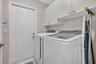 Laundry area with white cabinetry and patterned floor tile