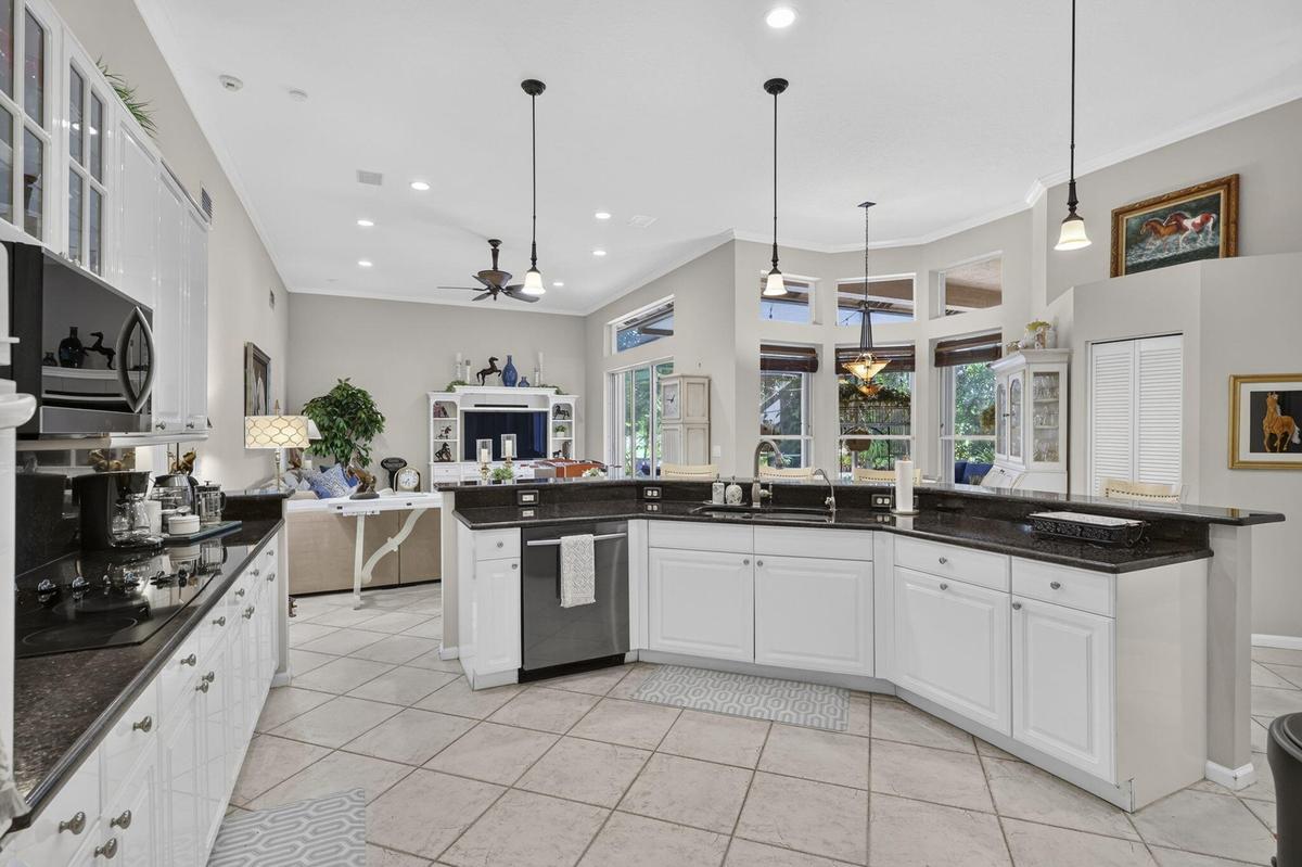 Kitchen featuring white cabinetry, dark countertops, recessed lighting, and tile flooring