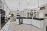 Kitchen featuring white cabinetry, dark countertops, recessed lighting, and tile flooring