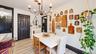 Light wood-finish flooring, dark trim accents, and a bronze chandelier with candelabra bulbs