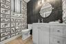 The main floor oversized half bath with designer wall treatments.