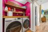 The laundry has built in folding area and storage shelves.