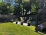 Expansive green lawn, a defined patio area, and a privacy fence