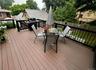 Expansive outdoor deck featuring composite Timber tech decking, black railings, and a Weber outdoor grill