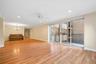 The entry hall leads to a large, sunlit living room with sliding glass doors to private terrace.