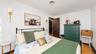 White walls with black trim, wood-finish flooring, dark wood-panel door, and two wall-mounted light fixtures