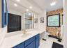 Elongated vanity with a single basin, quartz countertop, and gold-finish faucet