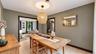 Hardwood-style flooring, woven pendant lighting, dark trim, and a framed wall mirror