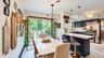 Gourmet kitchen with dark cabinetry, stainless steel appliances, and a central island with a light-toned countertop