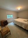 Recessed window with roller shade, neutral wall paint, flush mount ceiling light fixture, and wall-to-wall carpeting