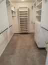 Walk-in closet featuring built-in shelving, hanging rods, and integrated drawers
