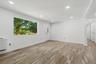 Dining Room with recessed lighting illuminates the open living area featuring wood-finish flooring, a large picture window, and a white entry door wit