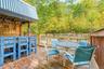 Spacious wood deck with a built-in bar, wood railing, and surrounding mature trees