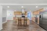 Kitchen featuring wood-finish flooring, recessed lighting, wood cabinetry, a center island, and stainless steel appliances