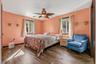 Primary bedroom with wood-finish flooring, and a ceiling fan with integrated lighting