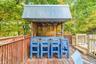 Outdoor bar structure featuring a corrugated metal roof, wood construction, and a bar counter with seating