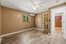 Wood-finish flooring with a ceiling fan, window, and split-system climate control unit