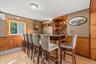 Built-in bar with wood-finish countertop, integrated shelving, and paneling accents