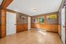 Wood-finish flooring with natural light, a window with wood trim, and a ceiling-mounted light fixture