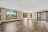Recessed lighting, wood-finish flooring, multiple windows with dark wood trim, and a built-in fireplace mantle