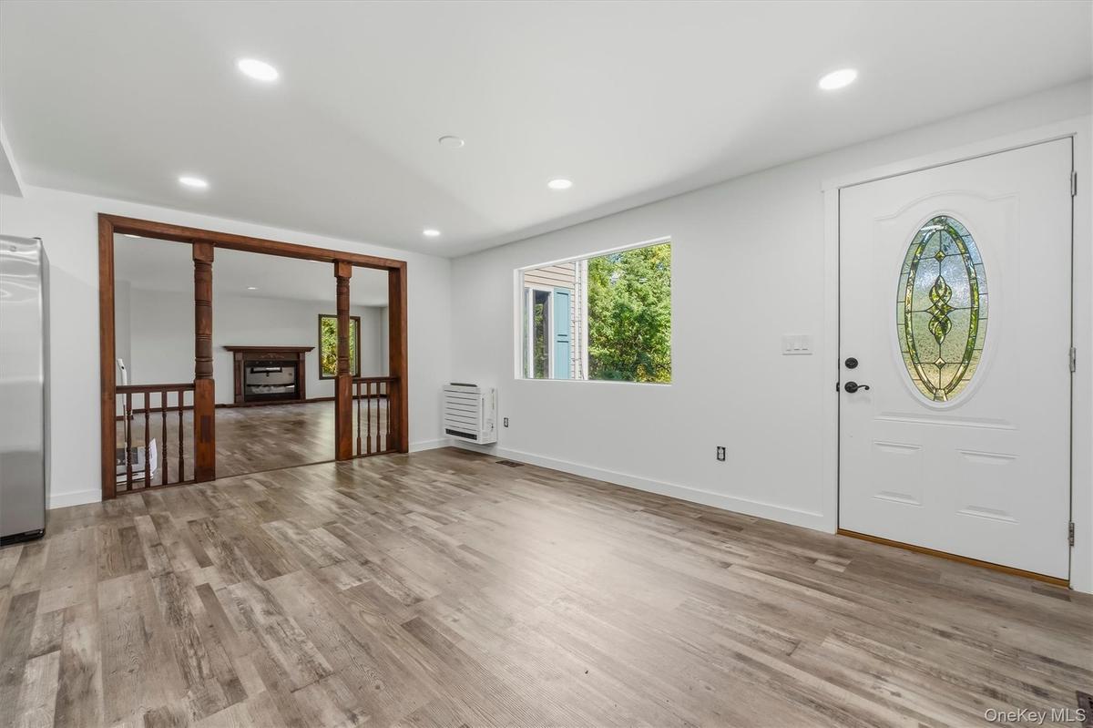 Dining room with Wood-finish flooring, recessed lighting, and a white entry door with an oval stained-glass insert