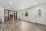 Dining room with Wood-finish flooring, recessed lighting, and a white entry door with an oval stained-glass insert
