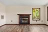 Wood-finish flooring with a propane fireplace and a carved wood mantelpiece