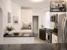 Contemporary kitchen featuring black granite countertops, white cabinetry, and stainless steel appliances (virtually staged)