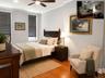 Hardwood flooring complements light gray walls with white crown molding(virtually staged)