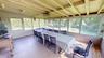Enclosed porch adjacent to the kitchen for additional dining.