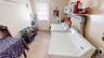 Large laundry Room with shelves and a door to the backyard.
