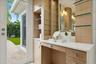 Built-in vanity with wood-finish cabinetry, a light-toned countertop, and integrated sink