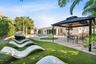 Expansive backyard featuring a lush green lawn and mature trees