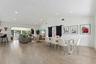 Open-concept living space showcasing wood-finish flooring, recessed ceiling lighting, and abundant natural light from large windows