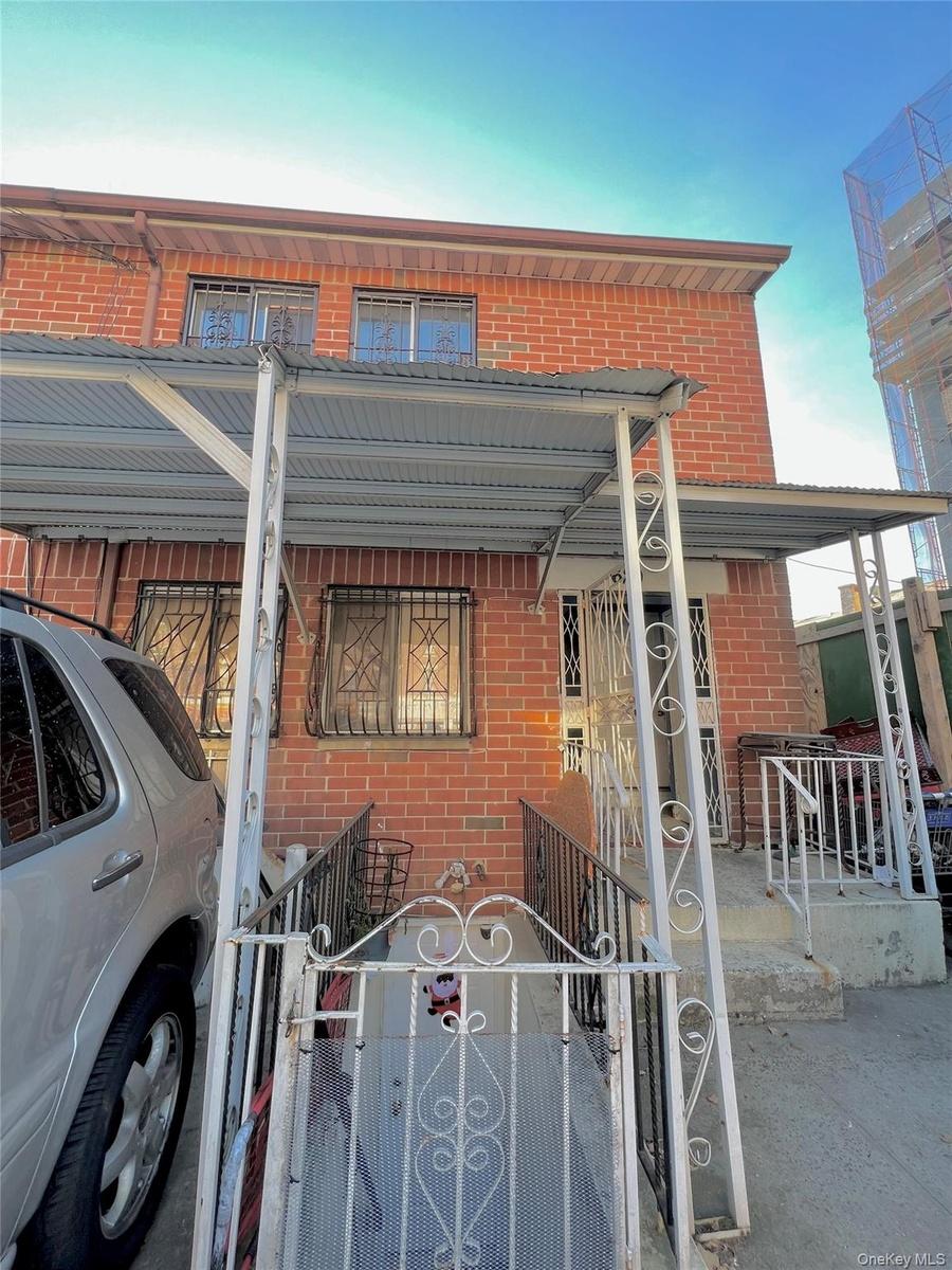 View of front of home featuring brick siding, a porch, a fenced front yard, and a gate