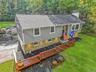 Split-level residence featuring gray siding and a stone-clad lower level