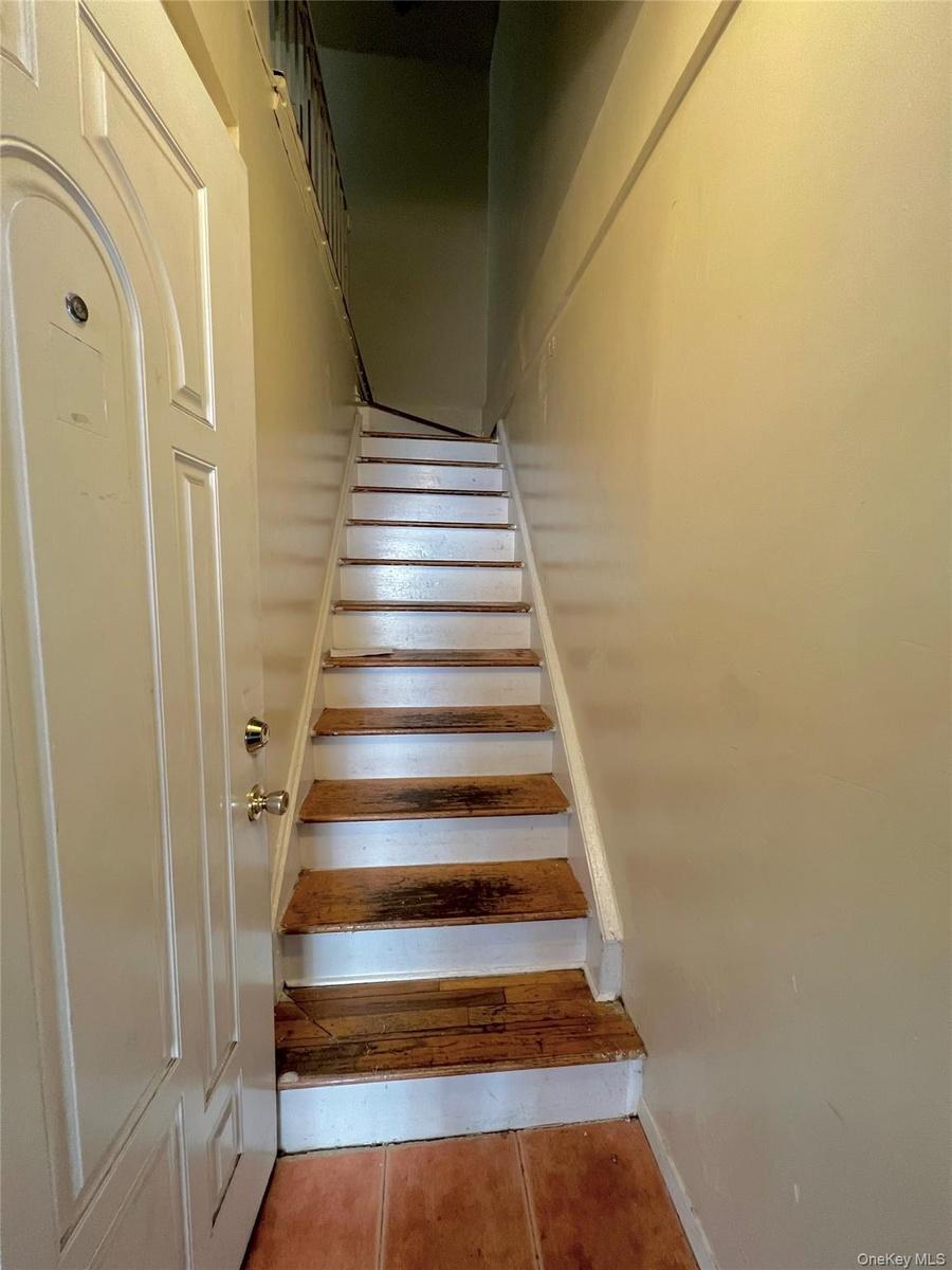 Stairway featuring tile patterned floors and baseboards