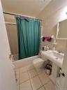 Full bathroom featuring toilet, shower / bath combination with curtain, tile walls, tile patterned flooring, and tasteful backsplash